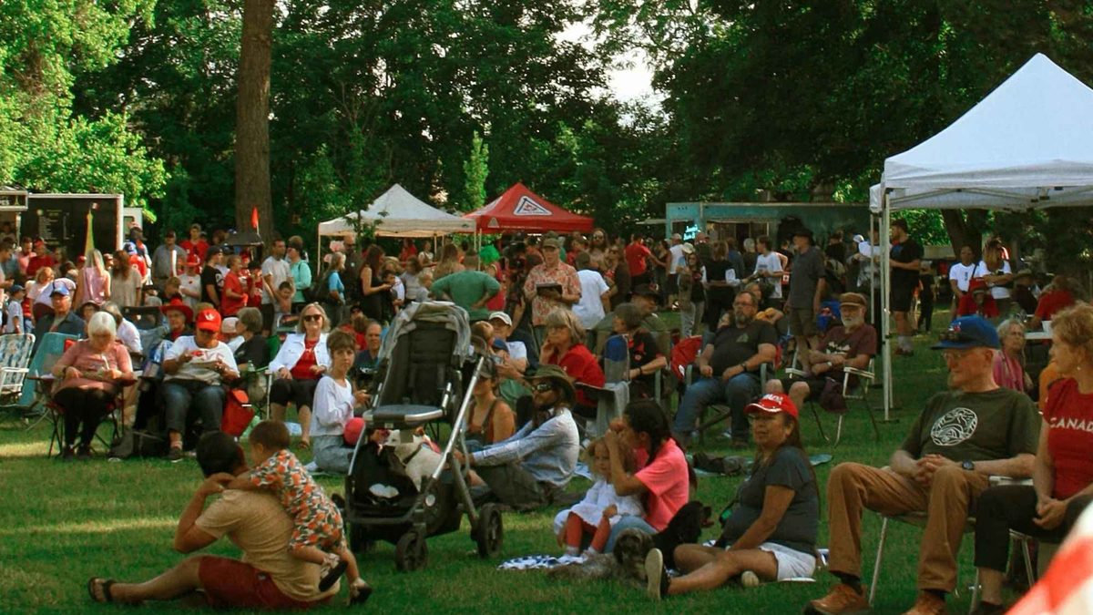 A crowd spread across the grass at a community celebration in the park
