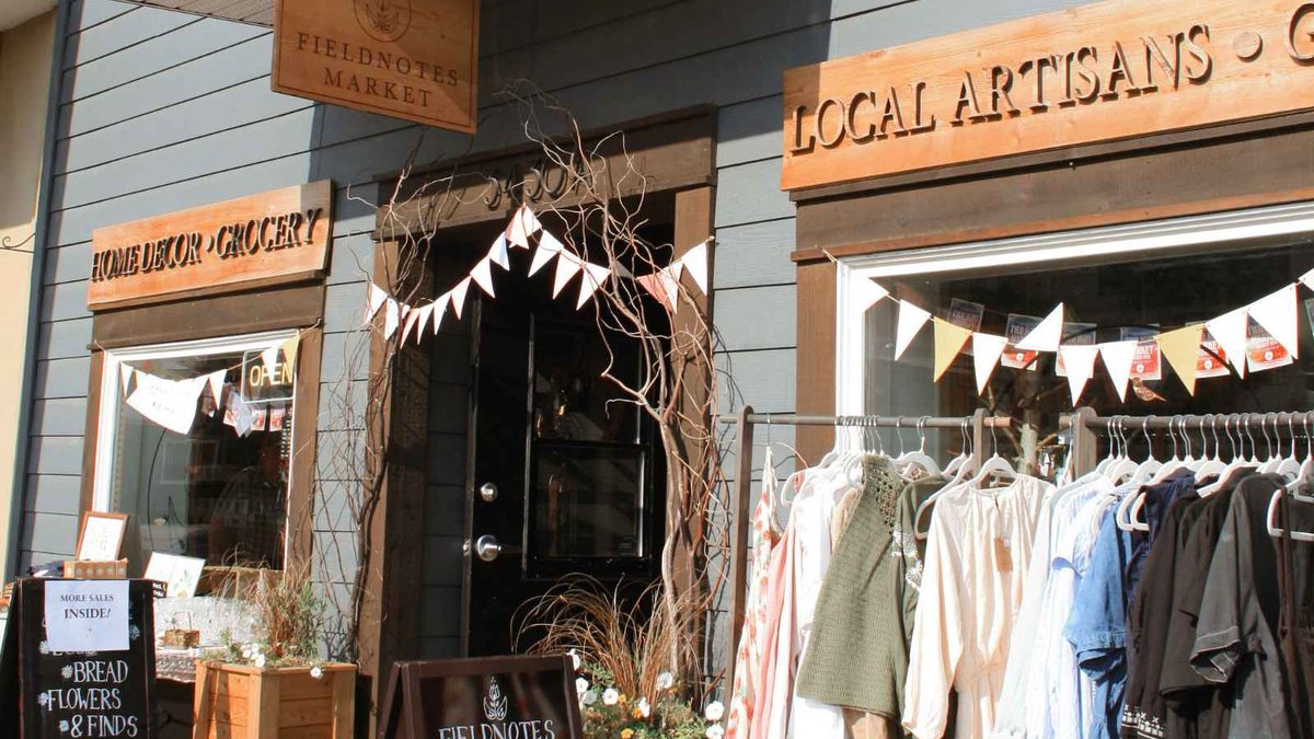 Clothing racks and bunting set out for a sidewalk sale on a downtown Armstrong storefront