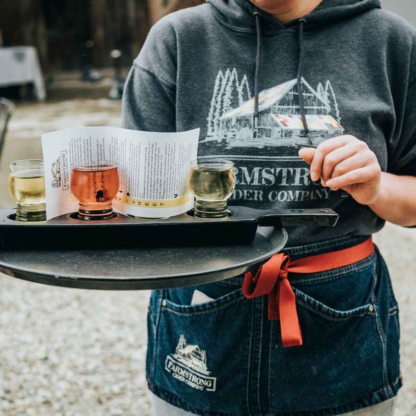 A server carrying a cider flight at a local cidery