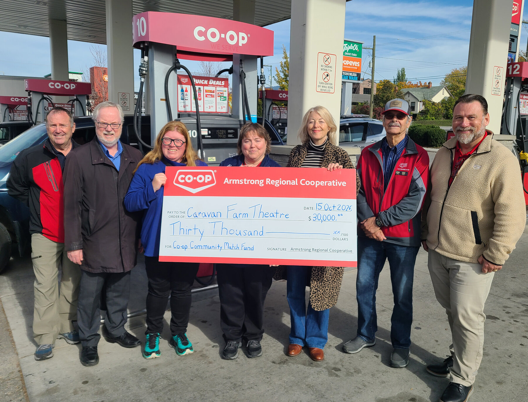 Representatives present a $30,000 Armstrong Regional Cooperative cheque to Caravan Farm Theatre.