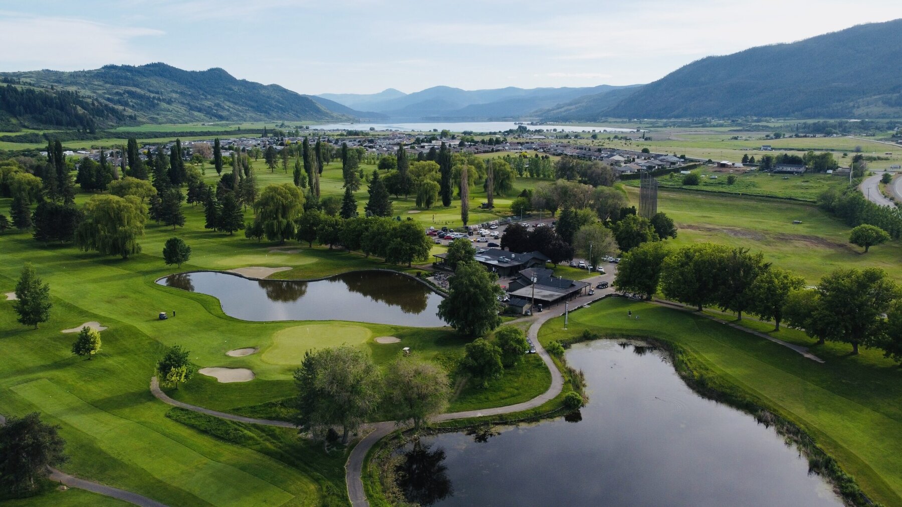 Aerial view of Spallumcheen Golf & Country Club, with greens, ponds, and the clubhouse.