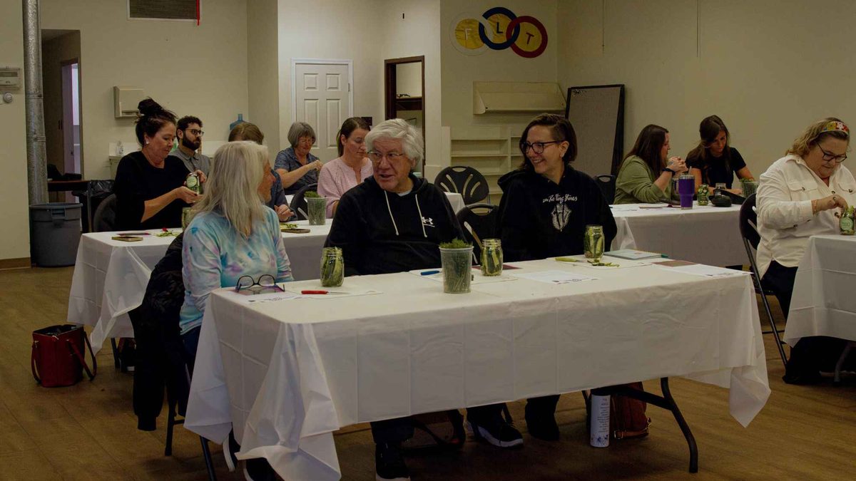 Guests seated at cloth-covered tables in the main hall during a workshop